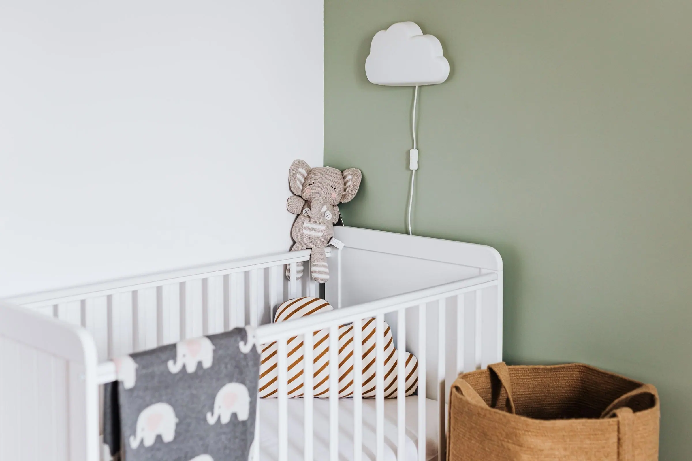 Wit ledikant met een babymatras in een lichte babykamer