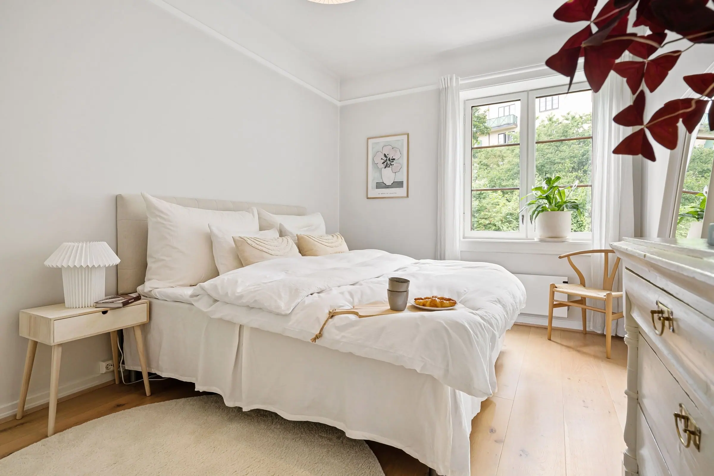 Lichte Scandinavische slaapkamer met een opgemaakt bed