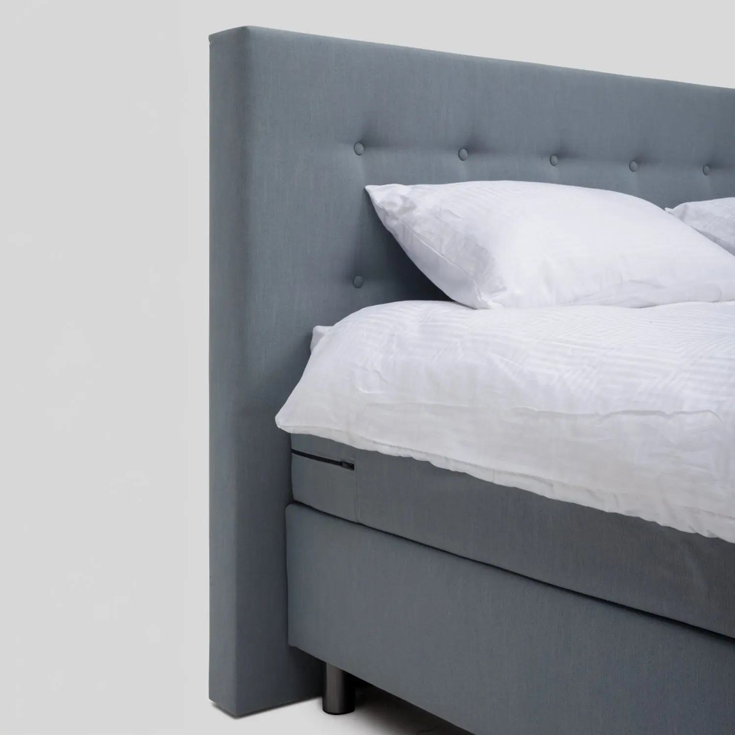 Detail van het gecapitonneerde hoofdbord van een boxspring