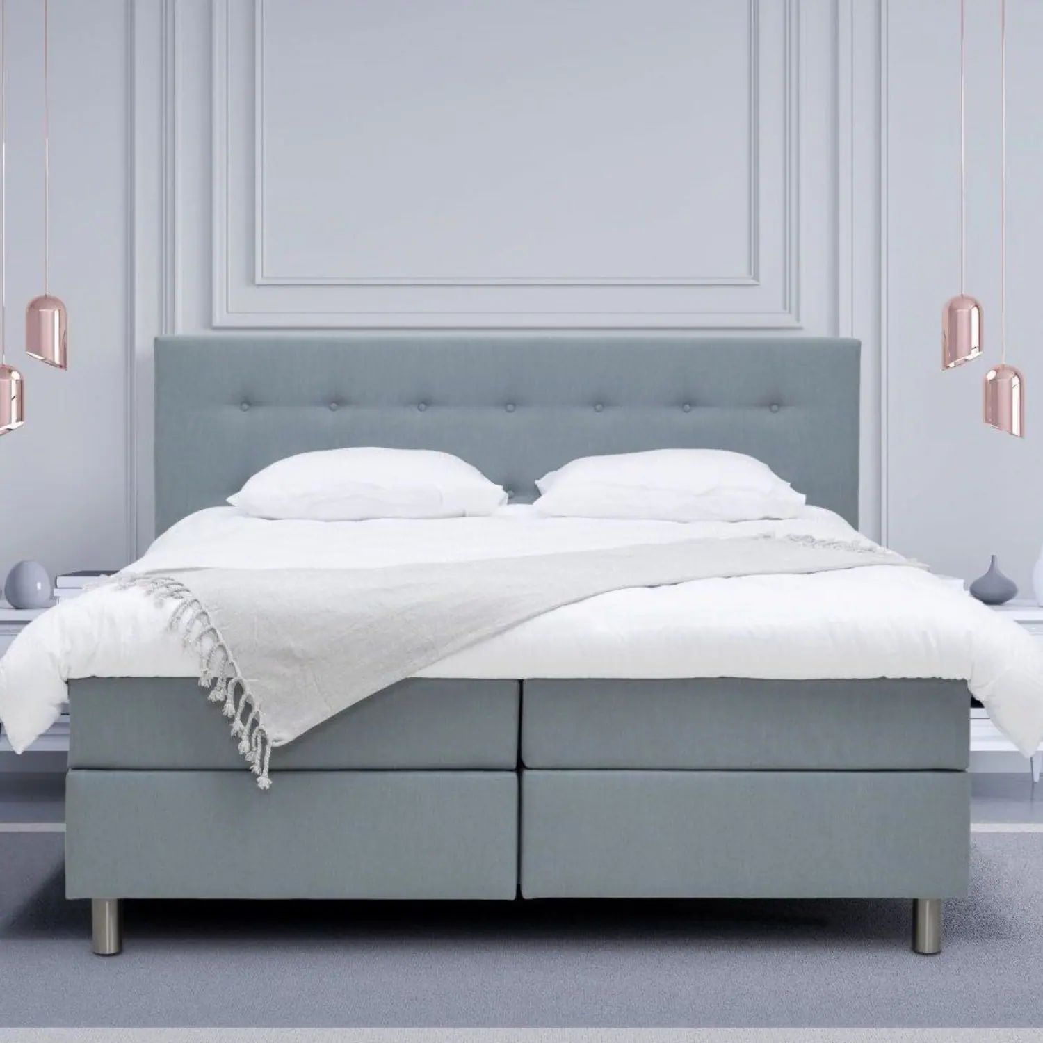 Blauwe boxspring met wit beddengoed in een lichte slaapkamer
